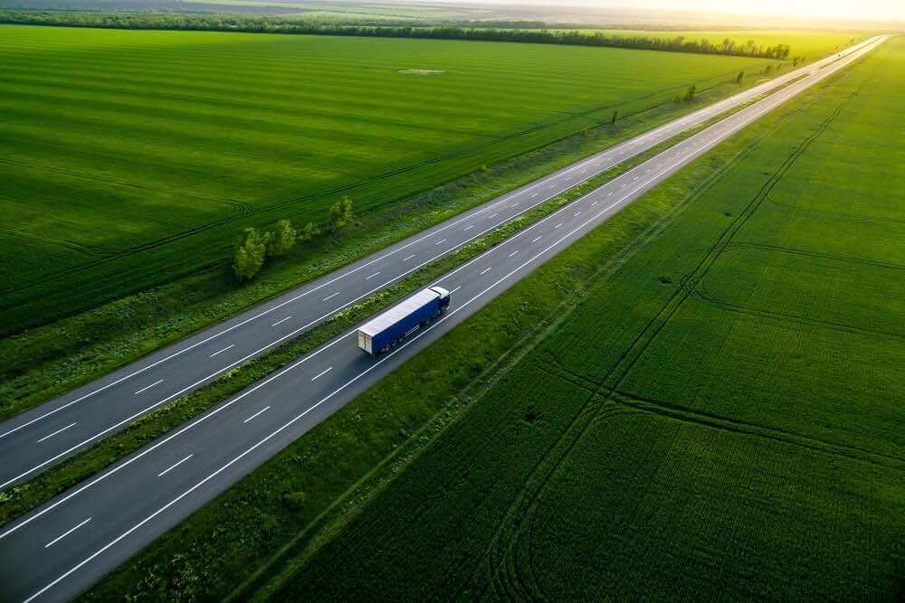 LKW transportiert Umzugsgut auf einer Autobahn in einer grünen Umgebung