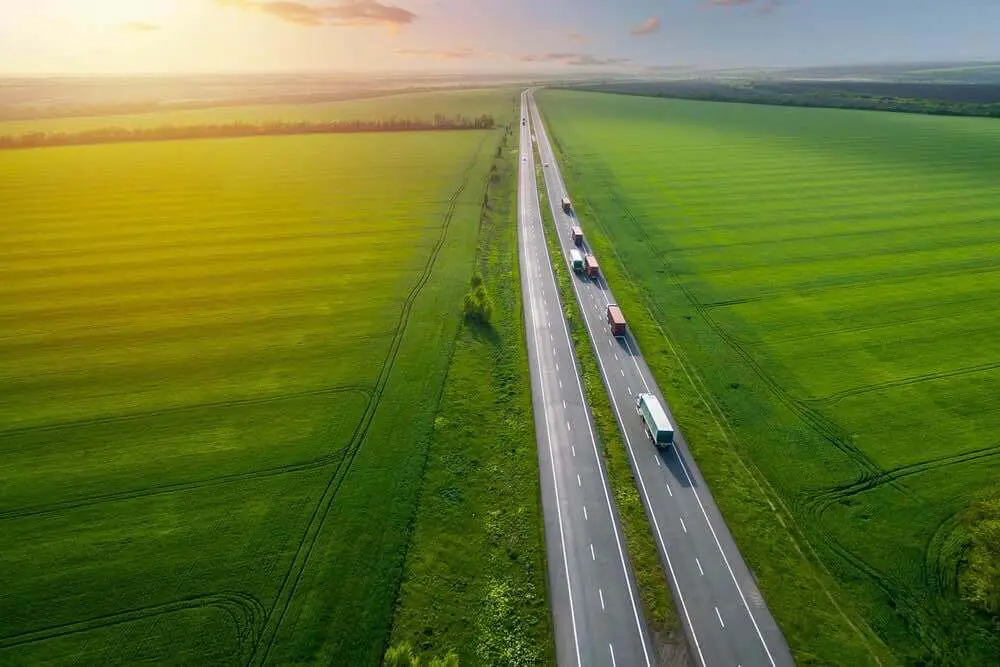 LKWs auf einen Autobahn transportieren Umzugsgut in einer grünen Umgebung